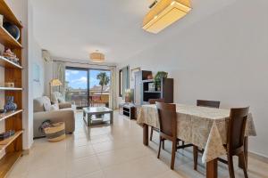 a dining room with a table and a living room at Pilar Luxury Apartment in Benalmádena