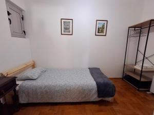 a bedroom with a bed and two pictures on the wall at Casa do Pisco in Sardoal