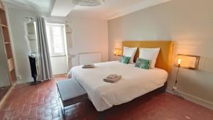 a bedroom with a large white bed with two towels on it at Le gîte de Varanges in Givry