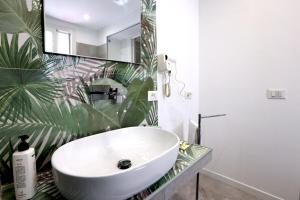 a bathroom with a white sink and a large plant at Ivi's House in Palermo +17 photos