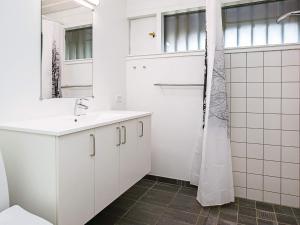 a white bathroom with a sink and a shower at 6 person holiday home on a holiday park in Karrebæksminde in Karrebæksminde