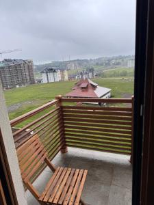 a wooden bench sitting on a balcony with a view at J&M Apartman Zlatibor in Zlatibor