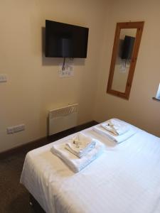a room with a bed with two towels on it at The Saltley Inn in Birmingham