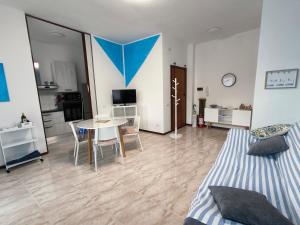 a bedroom with a bed and a table and a kitchen at Appartamento AZZURRO in Pesaro