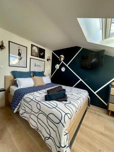 une chambre avec un grand lit avec un mur bleu dans l'établissement Appartement Chic & Élégant proche de la mer, à Yffiniac