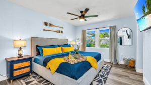 a bedroom with a blue bed and a ceiling fan at Peanut Island Paradise I 4 Mins to Island Shuttle! in West Palm Beach