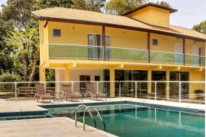 a house with a swimming pool in front of it at Pousada Cabeça do Indio - Trindade in Trindade