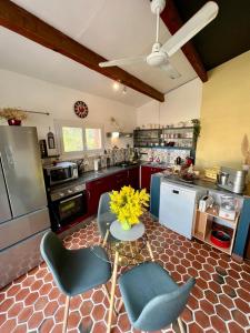 a kitchen with a table with yellow flowers on it at Bienvenue chez Sandrine in Laredorte
