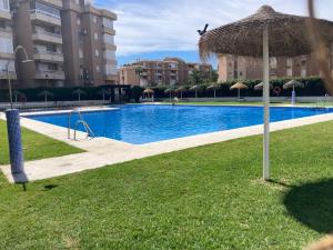 een zwembad met een grasparasol en enkele gebouwen bij ATICO AMBERES SEAVIEW PENTHOUSE - Torrox Costa in Castillo Bajo