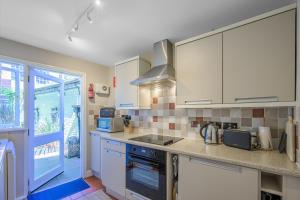 a kitchen with white cabinets and a stove top oven at St. John’s hill - with parking in Shrewsbury
