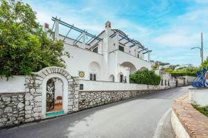 a house with a stone wall and a street at Villa nella curva della funicolare, Capri in Capri