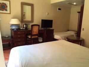 a hotel room with a bed and a desk with a mirror at فندق ريزورت اند سيا العالمين in El Alamein