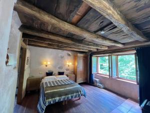 a bedroom with a bed in a room with wooden ceilings at Casa Rural Ecológica Kaaño Etxea el Bosque y la Naturaleza Sentir in Arrarats