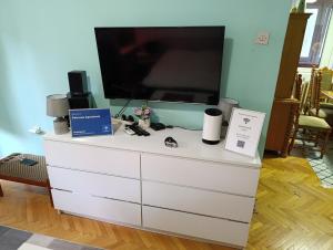 a white dresser with a large tv on top of it at Petronas Apartment in Niš