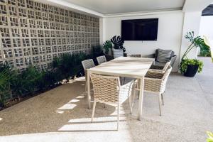 a white table and chairs with a television on a wall at Casa Ivanna Vallarta in Puerto Vallarta