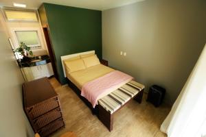 a small bedroom with a bed and a green wall at Casa Ensolarada entre montanhas e o rio na Praia do Paúba in São Sebastião +32 photos
