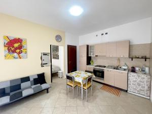a kitchen and a living room with a couch and a table at La Colonna 2km dal Centro in Siena