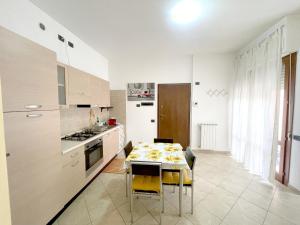 a kitchen with a table and yellow chairs in a room at La Colonna 2km dal Centro in Siena +1 photo
