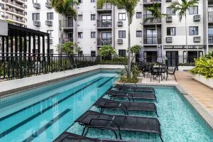 a swimming pool with chairs and a building at Apartamento Carioca in Rio de Janeiro