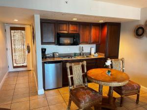 a kitchen with a table and a table and chairs at Beso Del Sol Resort in Dunedin