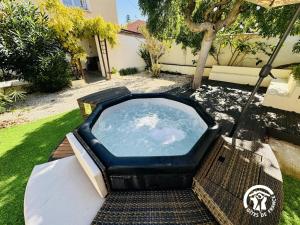 una bañera de hidromasaje en el patio trasero de una casa en Maison Magnolia, en Marcorignan