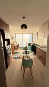 圣地亚哥Centenario 1151- 806A的客厅里有一张桌子和一个厨房