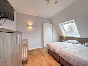 Un dormitorio con una cama y un televisor en la pared. en Villa superieur 64, en Colijnsplaat