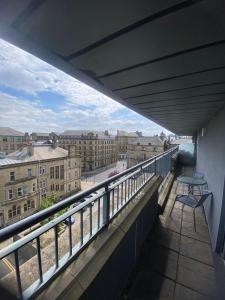 a balcony with a table and a view of a city at Modern 1-Bed Flat with Balcony in Bradford