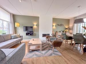 una sala de estar con un sofá y una mesa en Villa superieur 64, en Colijnsplaat