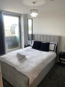 a bedroom with a large bed with a stuffed animal on it at Modern 1-Bed Flat with Balcony in Bradford