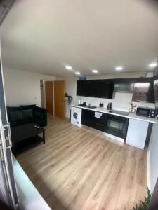 a living room with a couch and a kitchen at Modern 1-Bed Flat with Balcony in Bradford