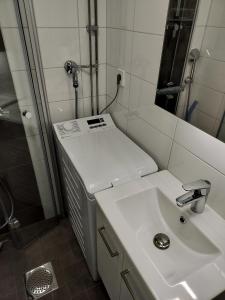 a bathroom with a sink and a shower at Parantolankatu modern one room apartment in Hyvinkää