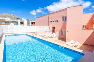 a swimming pool in front of a building with a house at Nice apartment with wifi and pool in Port de Pollensa