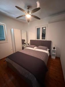 a bedroom with a bed with a ceiling fan at "Silente" Cozy Two-bedroom Apartment with sea view in Postira
