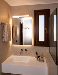 a bathroom with a sink and a mirror at Aeolia Seaside Residence in Kokkari in Kokkari +42 photos