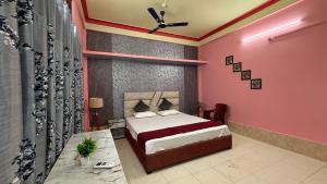 Un dormitorio con una cama con una pared rosa. en The Aurelia Inn, en Sibsāgar