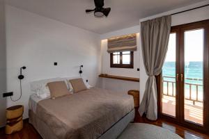 a bedroom with a bed and a balcony with the ocean at Aeolia Seaside Residence in Kokkari in Kokkari