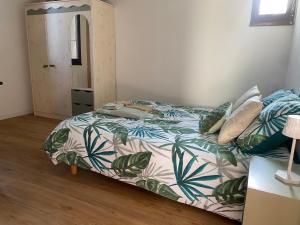 a bedroom with a bed with a green and white comforter at Maison proche centre village in Grignan +19 photos