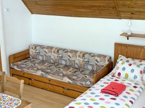 a small bedroom with a bed and a couch at Lívia Apartman in Balatonfüred