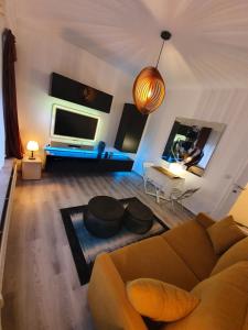 a living room with a couch and a tv at Antwerp Hideaway, outside of low emission zone in Antwerp