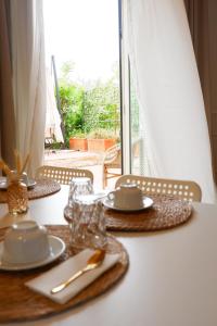 a table with plates and utensils on a table with a window at Tenuta Maison Angelina in Formia