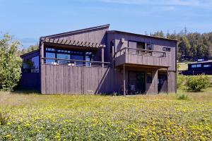 une maison sur une colline avec un champ de fleurs dans l'établissement Footloose, à Sea Ranch