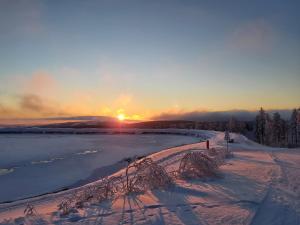 un tramonto su un lago ghiacciato con il sole sullo sfondo di Ferienwohnung Arendt inkl MeineCardPlus a Willingen