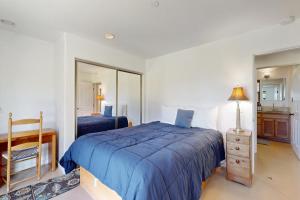 une chambre avec un lit bleu et un miroir dans l'établissement Footloose, à Sea Ranch