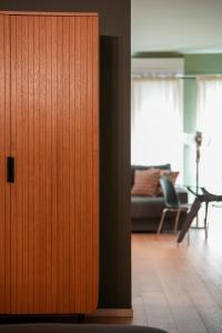 a wooden door in a room with a living room at LΛ DIMӨRΛ di KΛMΛ' in Cesena +20 photos