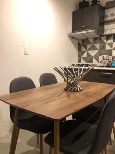 a wooden table in a kitchen with chairs around it at Casa con jardín y piscina ideal para el fin de semana in Temimilcingo +6 photos
