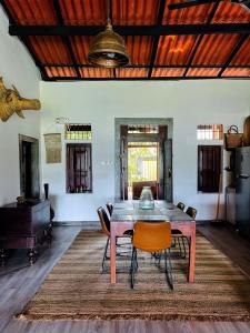 a dining room with a wooden table and chairs at Mati Ambalama in Ambalangoda +10 photos
