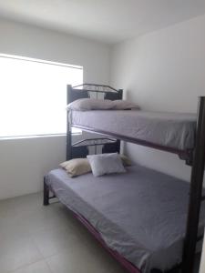 a room with two bunk beds and a window at Casa con jardín y piscina ideal para el fin de semana in Temimilcingo
