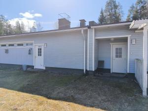 a white house with a garage at Kaksio maaseudun rauhassa in Välijoki