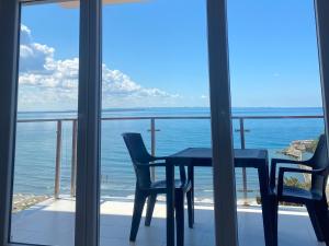 a table and chairs on a balcony with a view of the ocean at BlueWaveapartments 2 in Shëngjin +2 photos